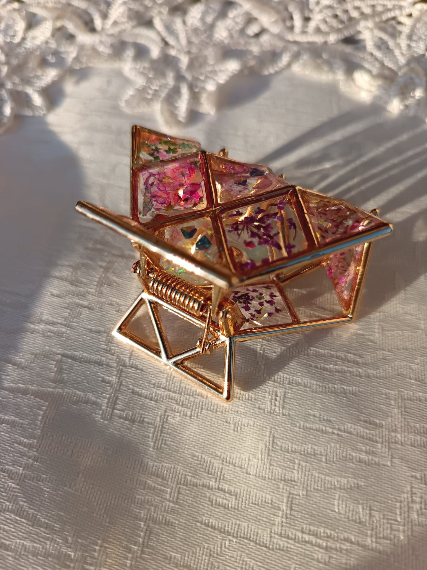 Dettaglio lavorazione clip Geometrie in fiore con riflessi e fiorellini
