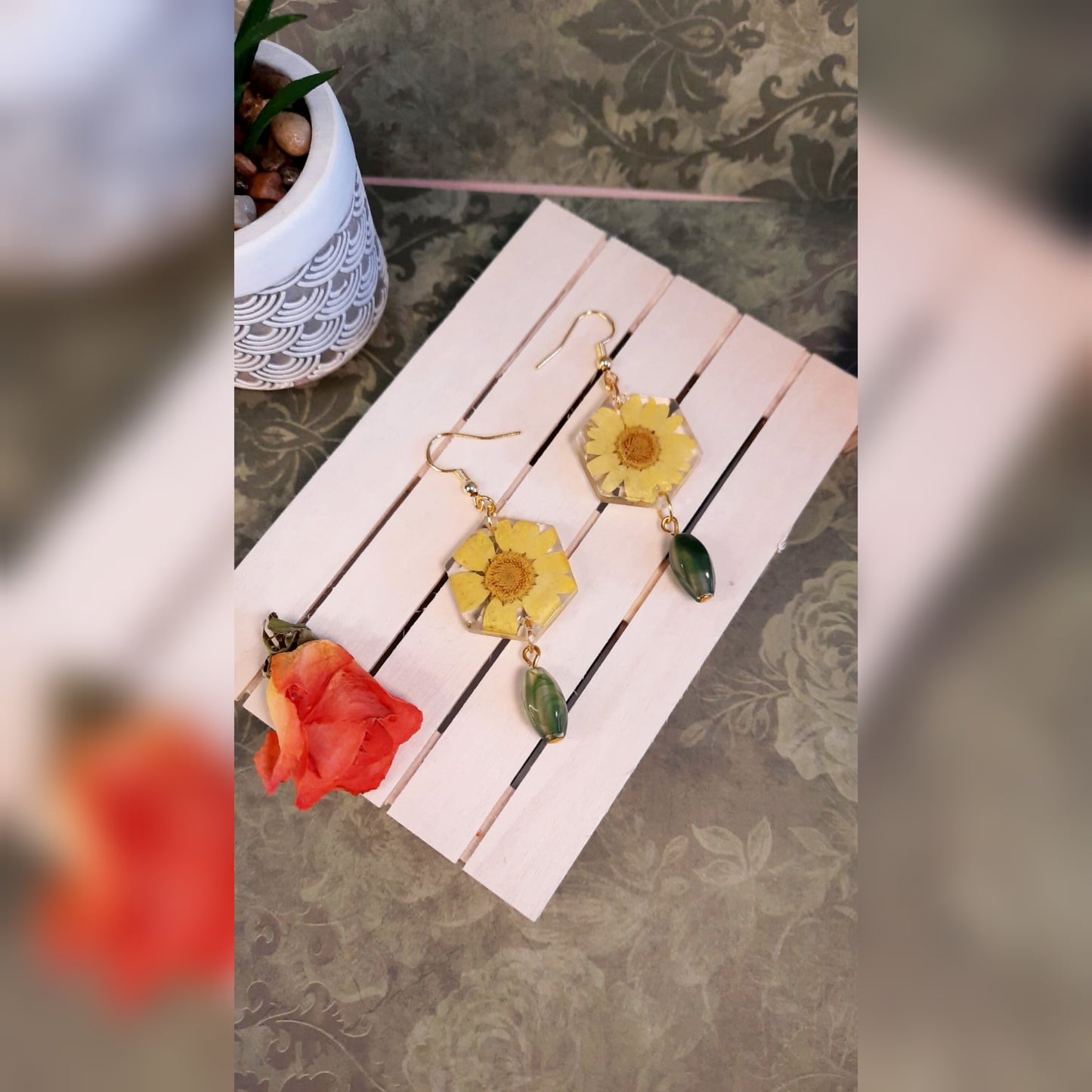 Dettaglio orecchini artigianali gialli con fiori veri
