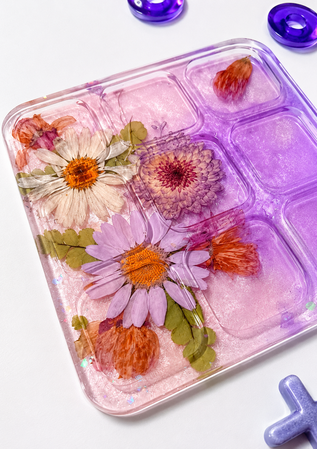 Dettaglio della base del tris in resina rosa e viola decorata con veri fiori essiccati
