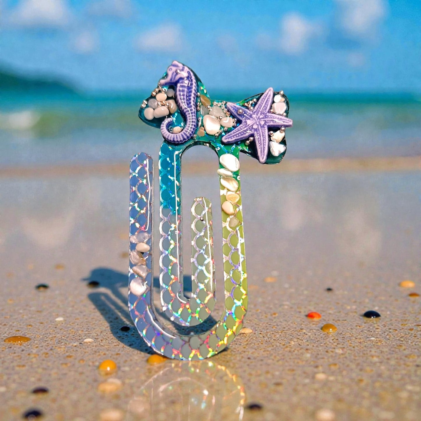 Segnalibro in resina blu con effetto olografico su sabbia di mare - MANIKOCREATIONS